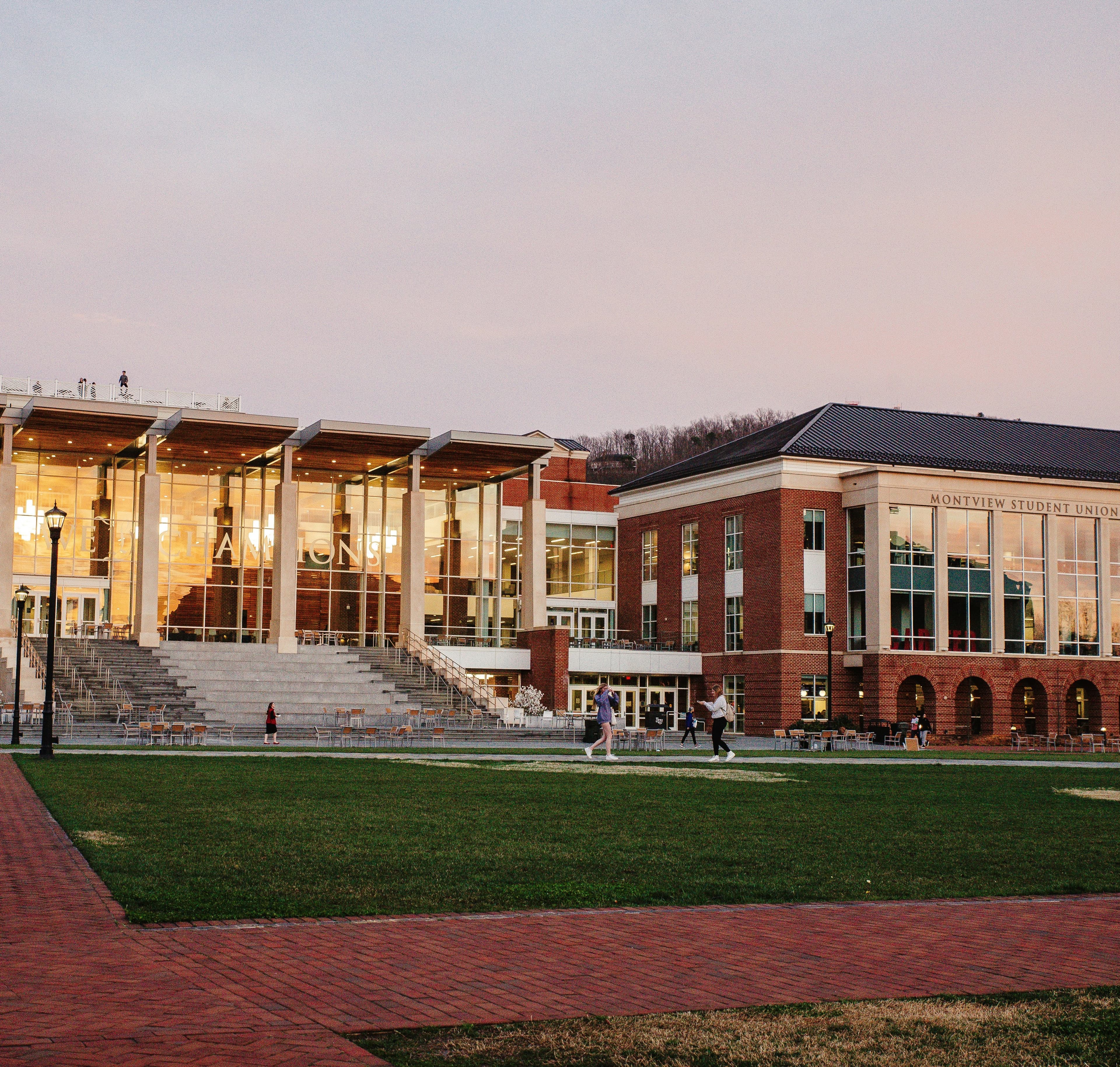 Modern college campus building with glass windows and brick architecture at dusk