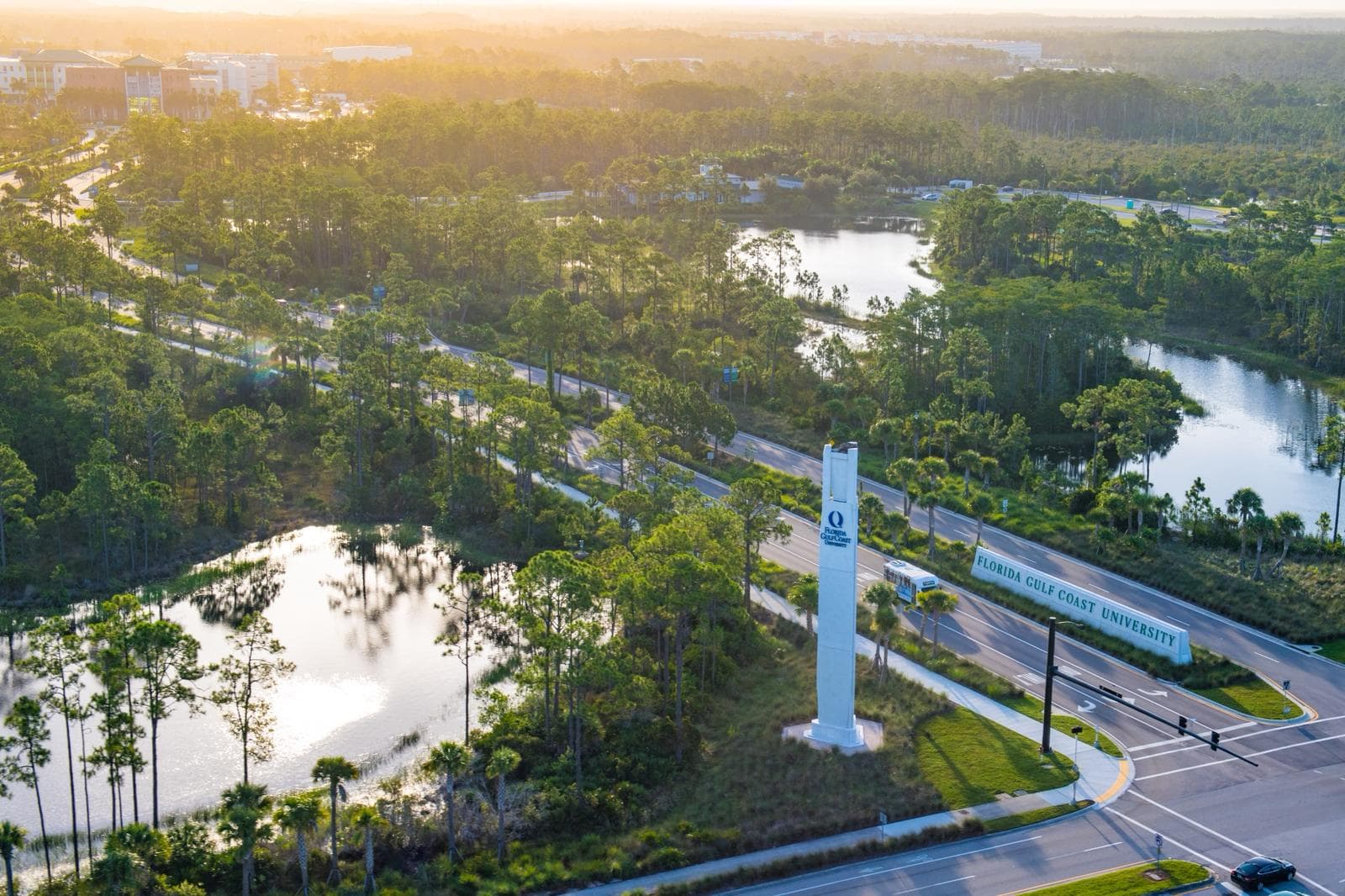 Aerial view of a college campus with scenic landscape, river, and modern facilities