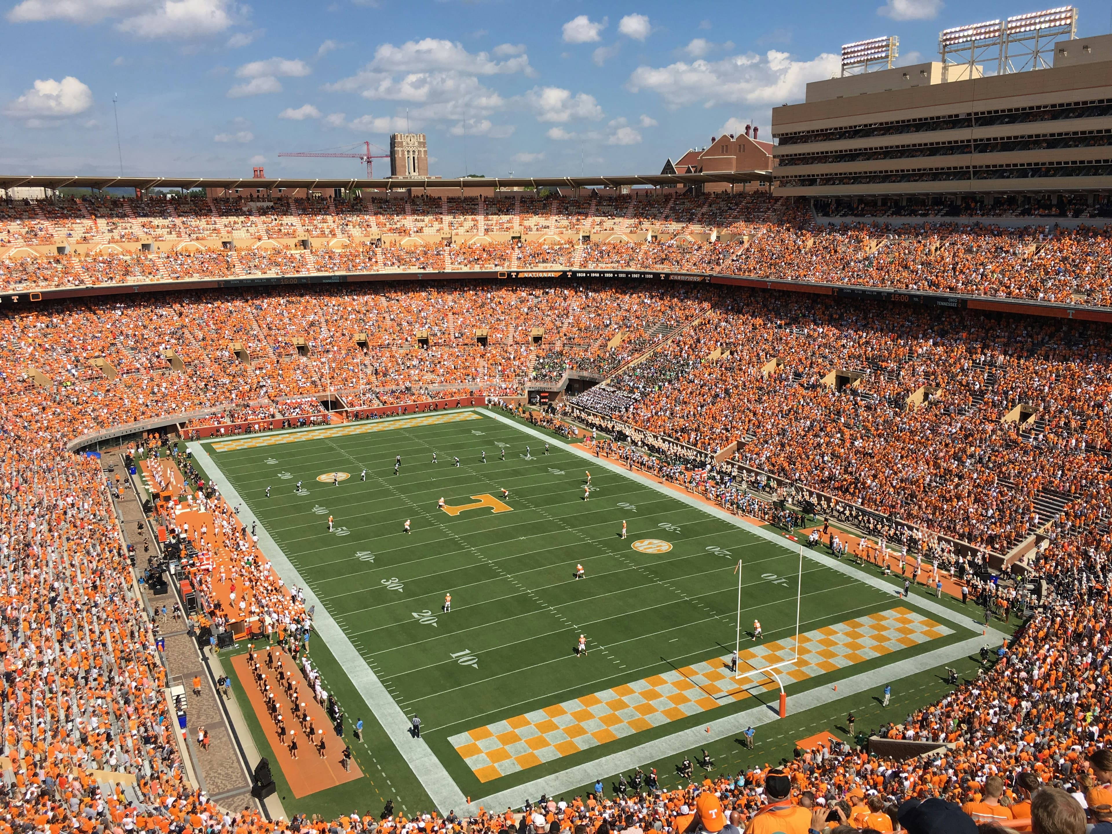 Large college football stadium filled with thousands of fans during a competitive game