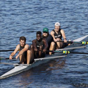 Four rowing student-athletes competing in a race as a team.