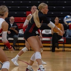 A college volleyball student-athlete bumps the ball during a match.