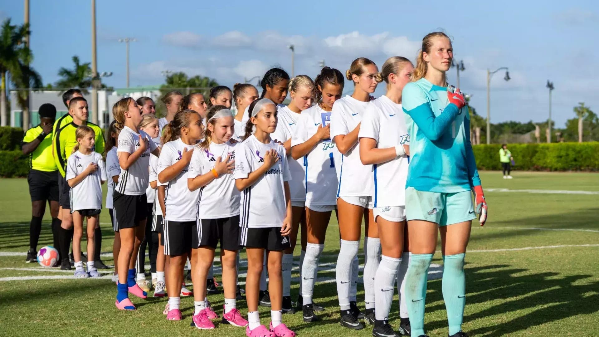 Florida Gulf Coast University Women's Soccer Team at the National Anthem Female college soccer players from Florida Gulf Coast University stand together with their right arm on their heart while listening to the U.S. national anthem before a game.