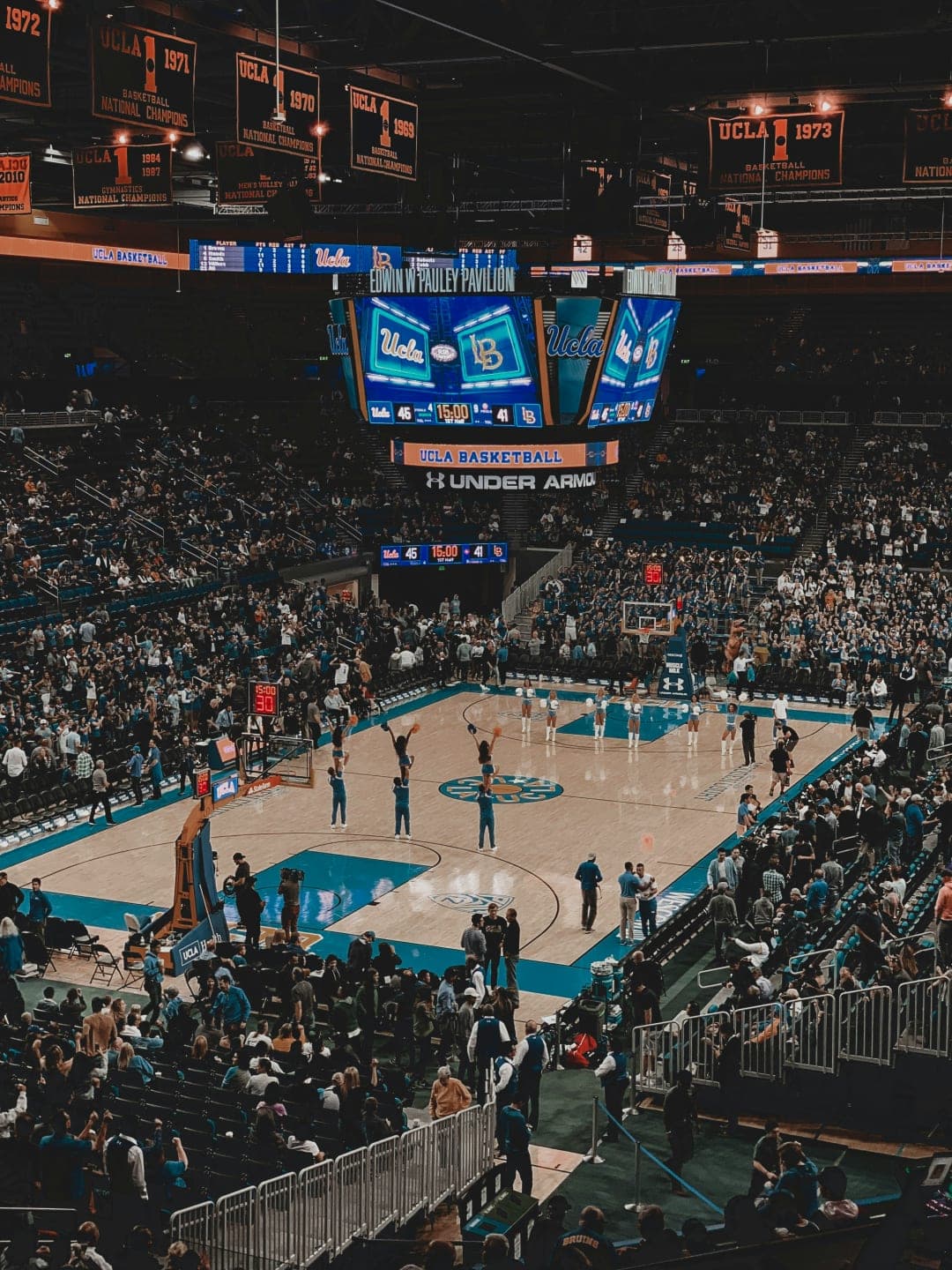 UCLA Basketball Game at Edwin W. Pauley Pavilion Arena UCLA basketball court stadium view with cheerleaders performing and fans in the stands
