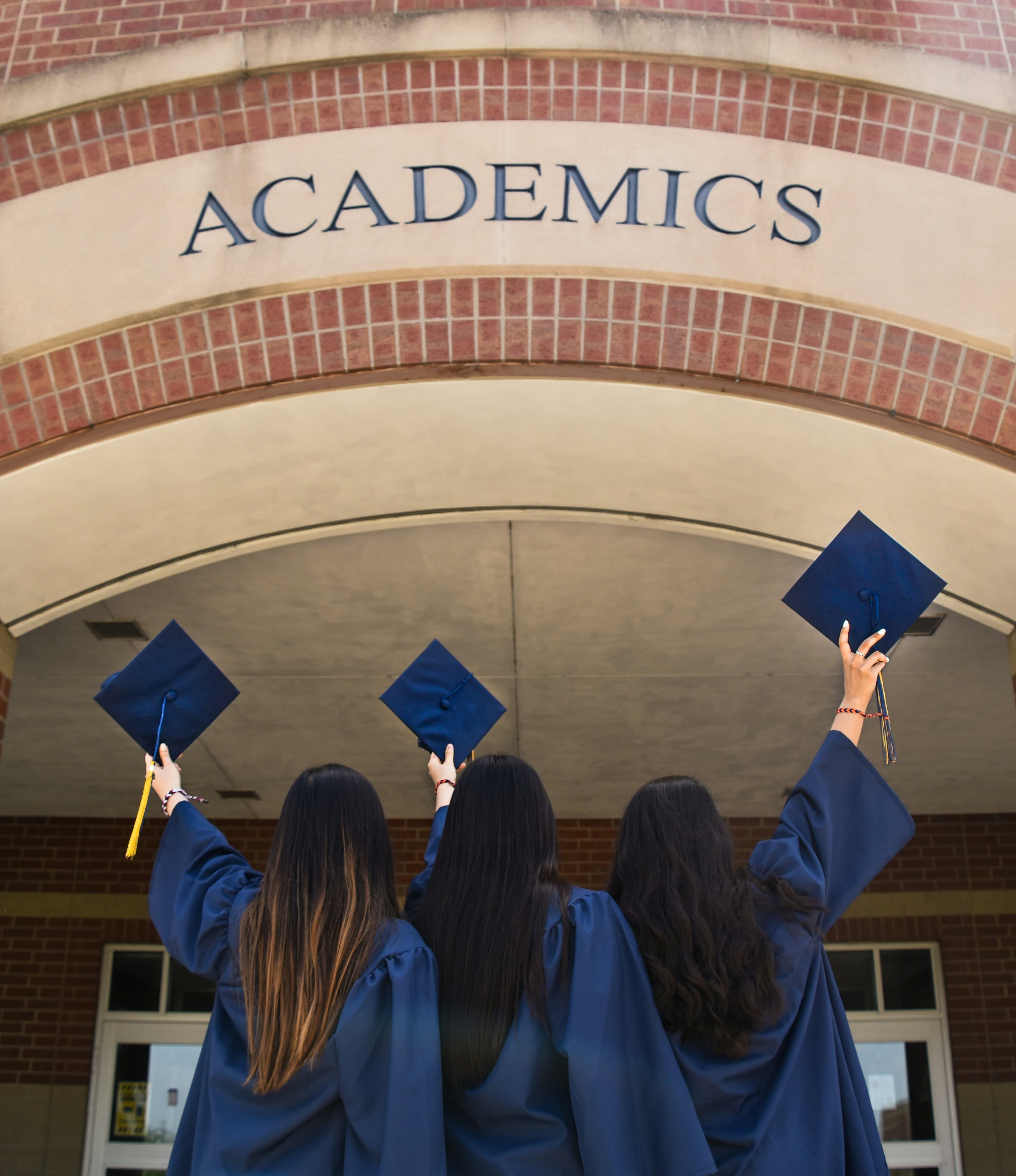 College Costs and Financial Aid Planning Graduation ceremony with academics sign and graduates in caps and gowns
