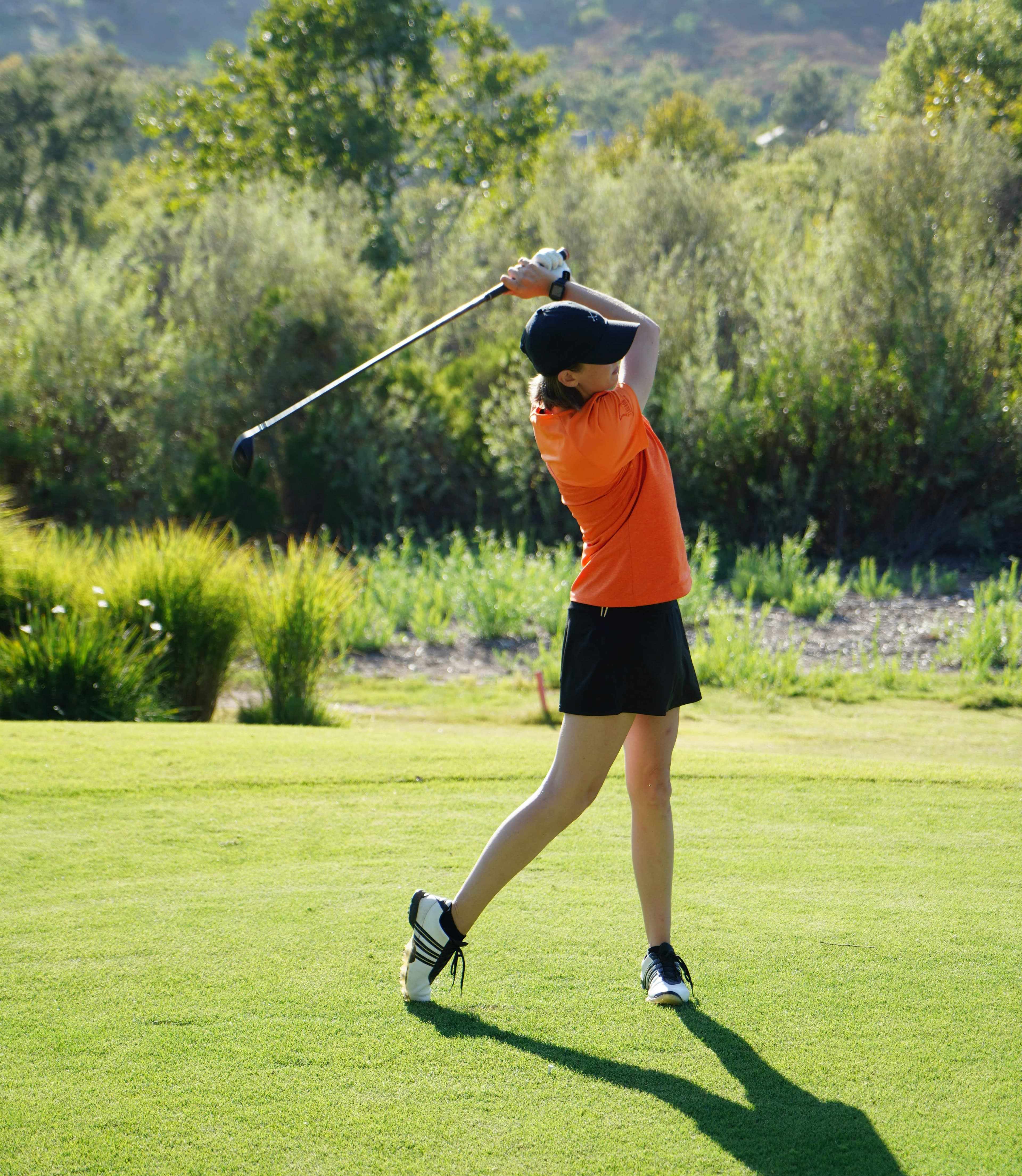 Young Female College Golfer Finishing Her Swing | Smarthlete Young female golfer finishing her swing.