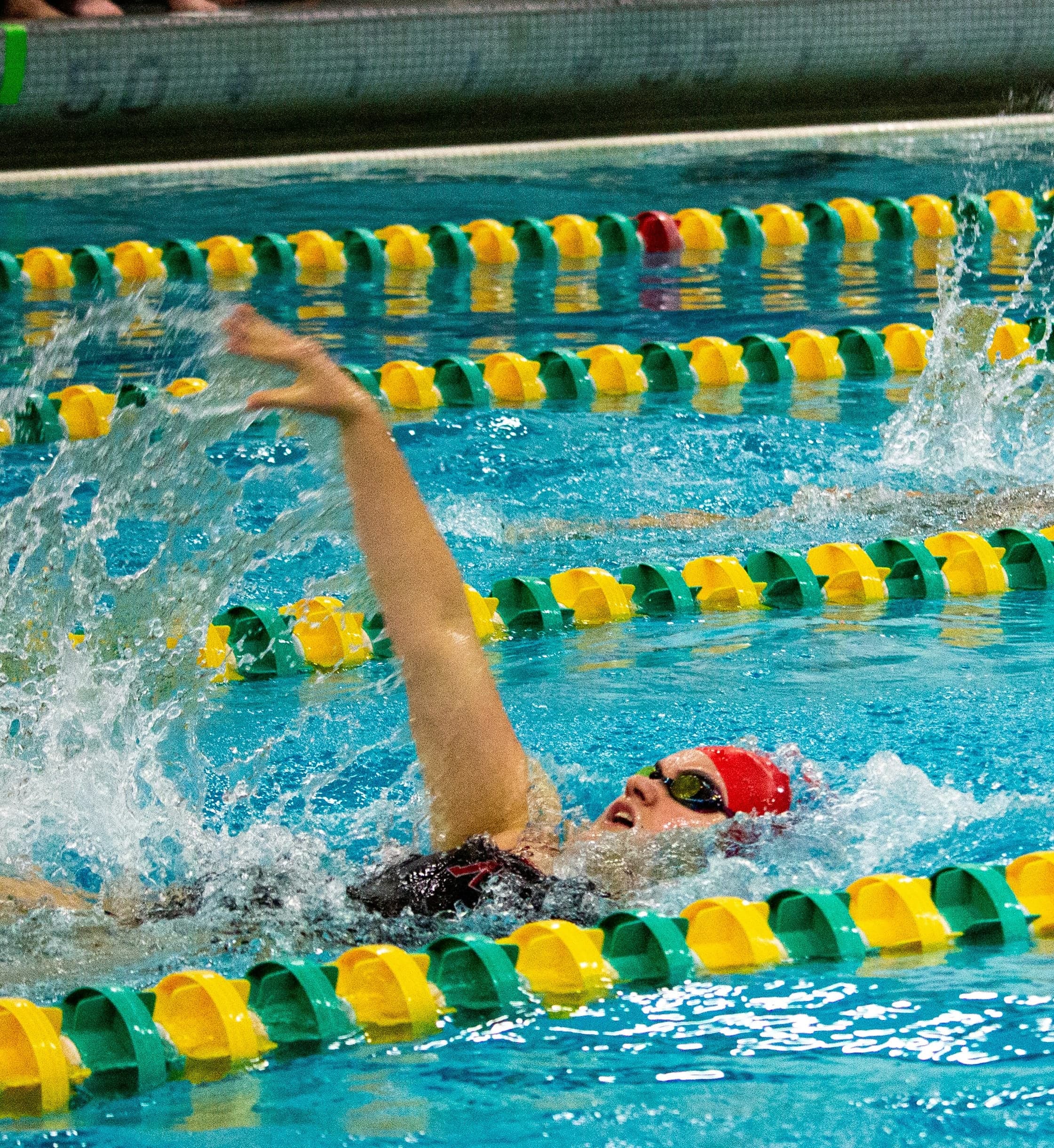 Female College Swimmer Doing Backstroke | NCAA Race Female collegiate swimmer doing backstroke during a race.