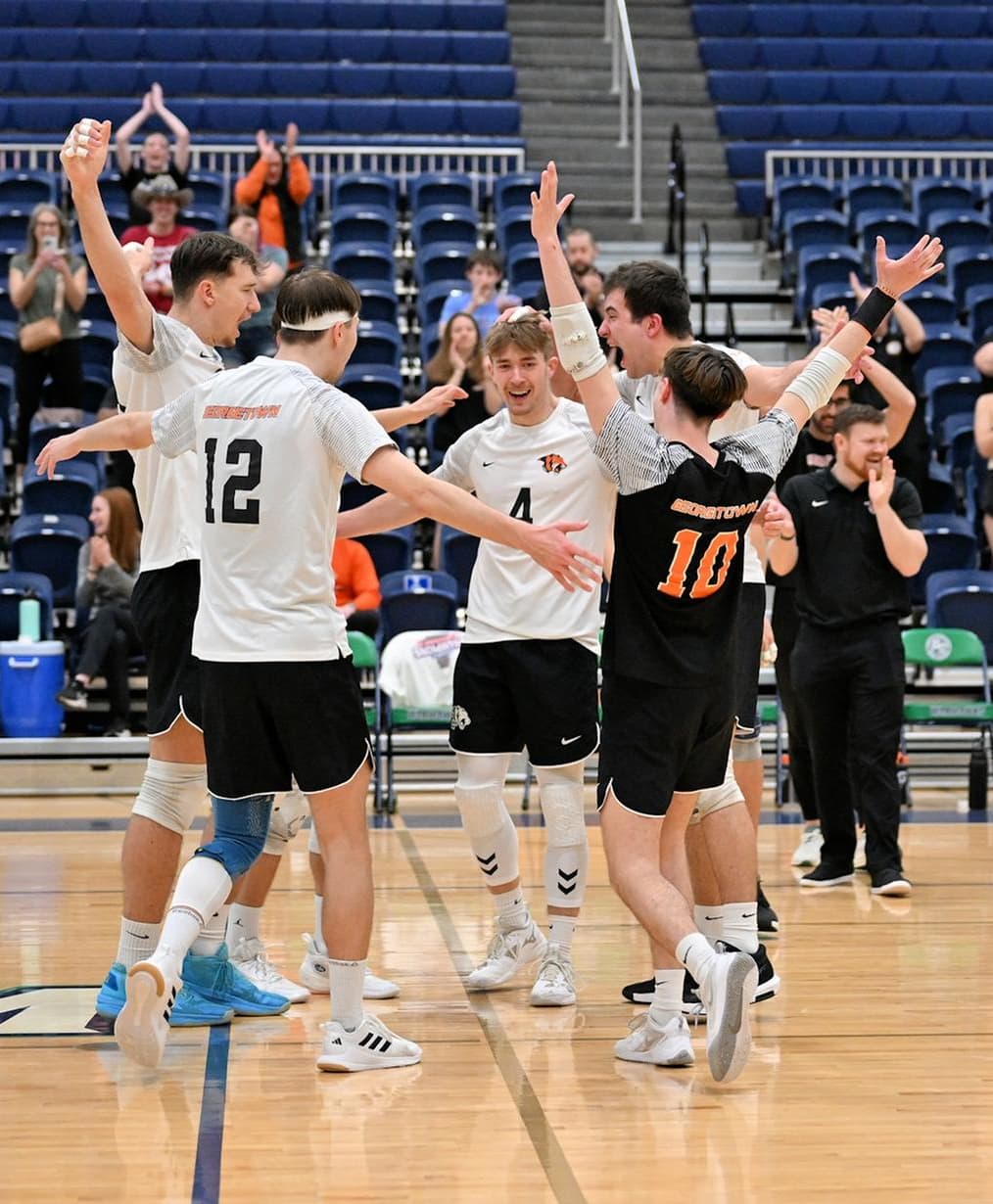 College Volleyball Players Celebrating a Point | Smarthlete Group of male college volleyball players celebrating a point on the court.