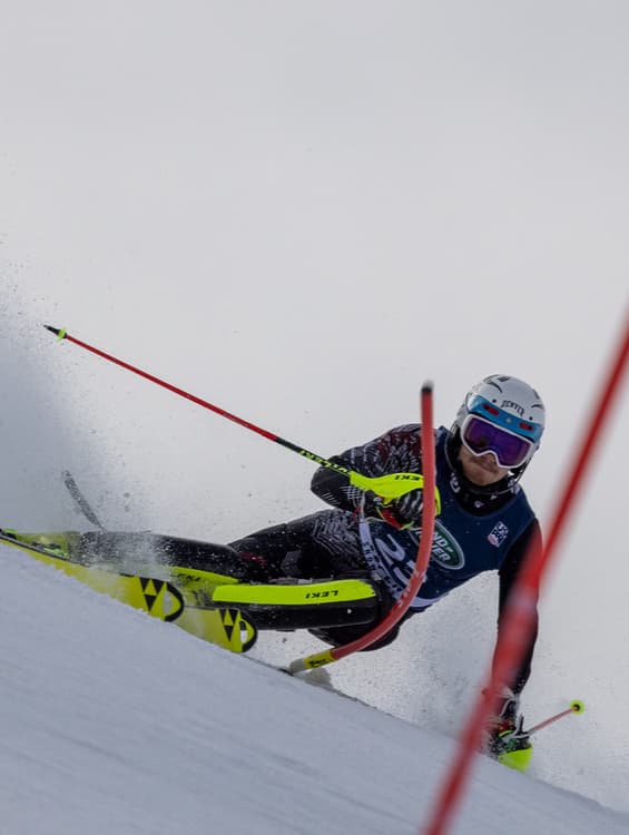 College Skier Doing Left Turn on Slalom Course | Smarthlete A college skier doing a left turn on a slalom course.