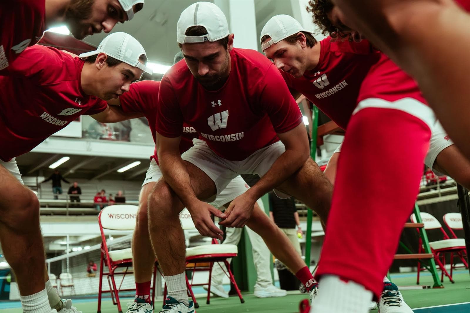 Herren-Tennisteam der University of Wisconsin - Madison Das Herren-Tennisteam der University of Wisconsin - Madison in einem Huddle vor einem Spiel.
