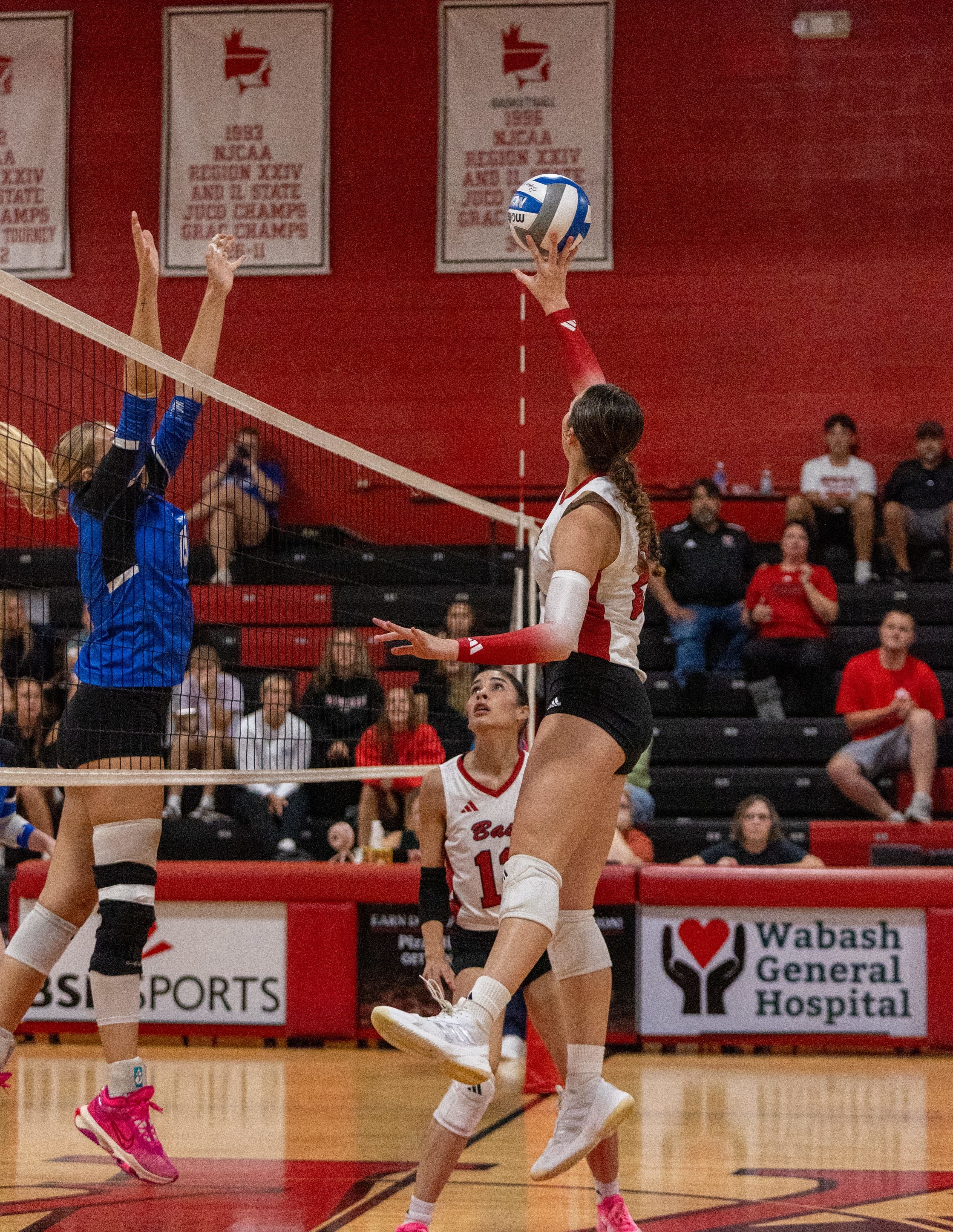 Female College Volleyball Player Jumping to Hit the Ball | Smarthlete Female college volleyball player jumping to hit the ball over the net.