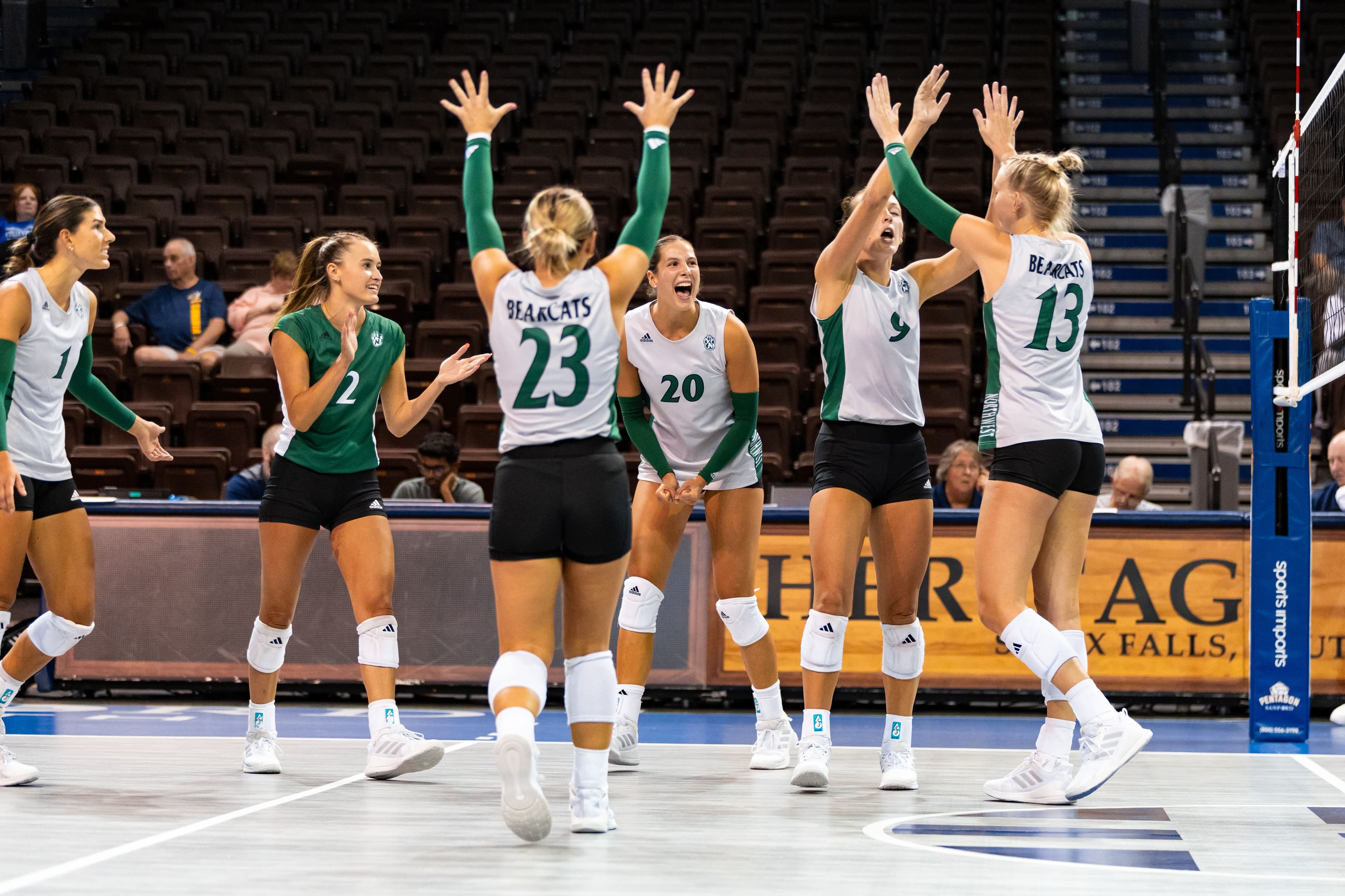 College Volleyball Players Celebrating at Northwest Missouri State University A group of college volleyball players celebrating a point on the court.